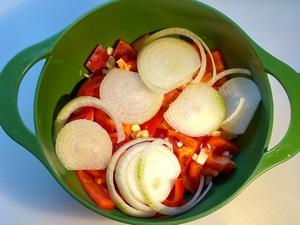 The chopped red pepper, with sliced onion and garlic.